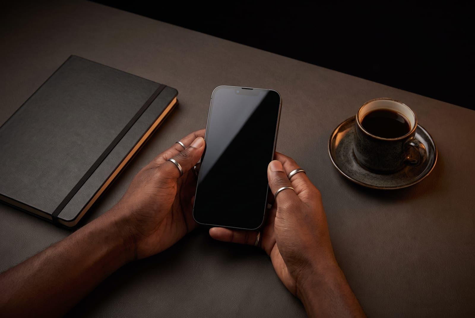 Hands holding a phone above a desk, the moment before an identity document is captured